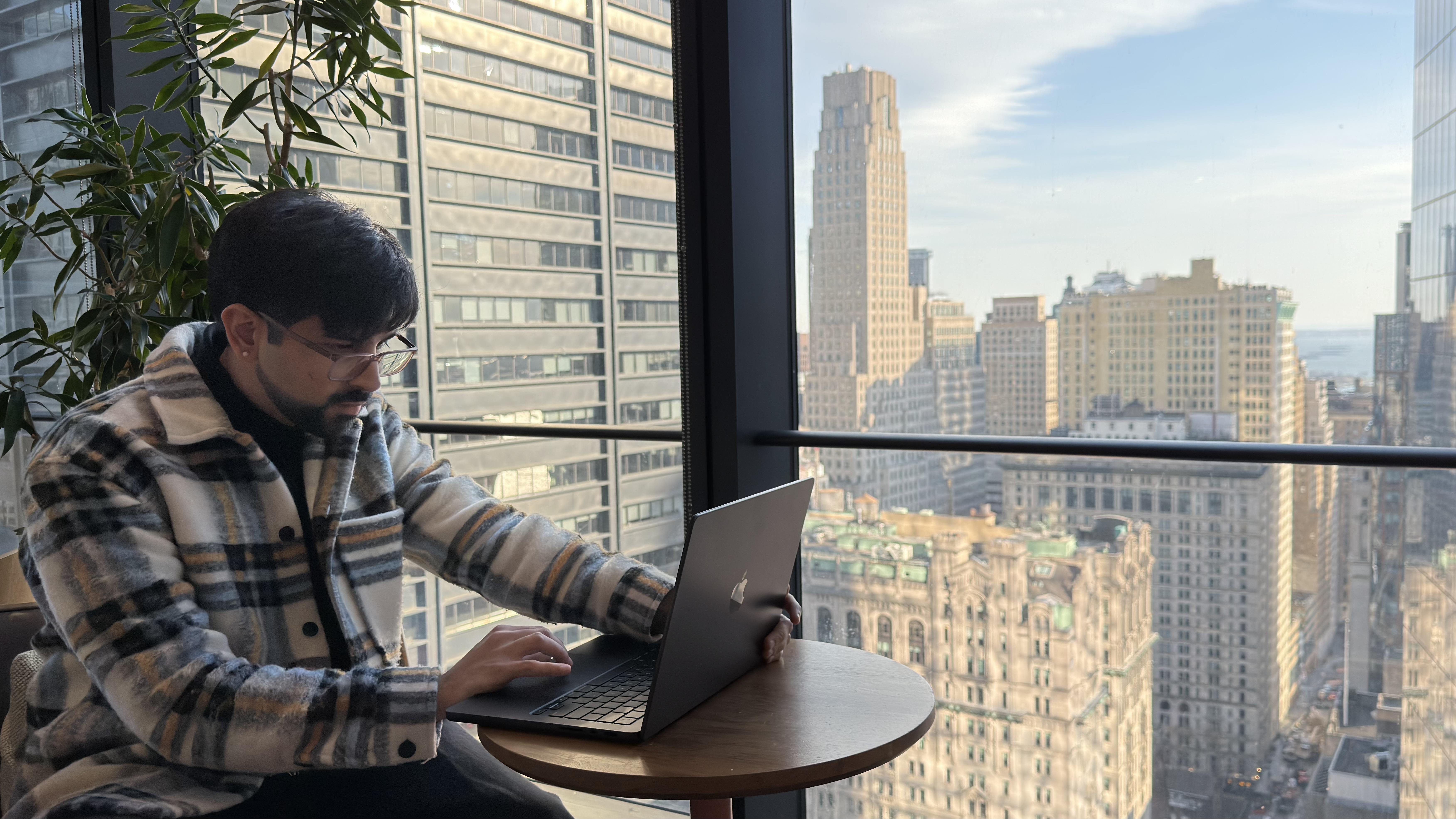 Rudransh working by a window overlooking New York