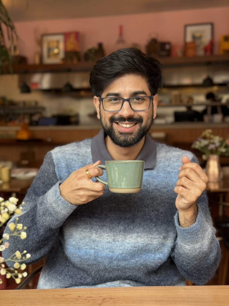 Rudransh smiling over a cup of coffee